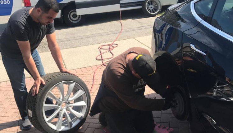 two men changing a tire in toronto