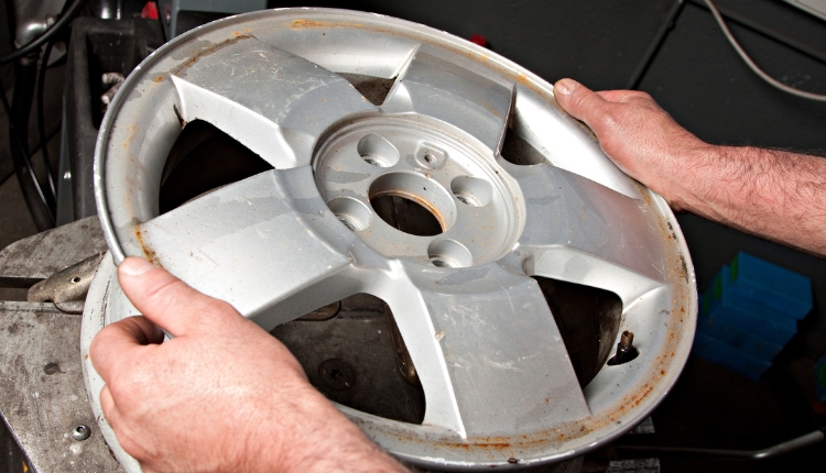 mechanic replacing damaged rim